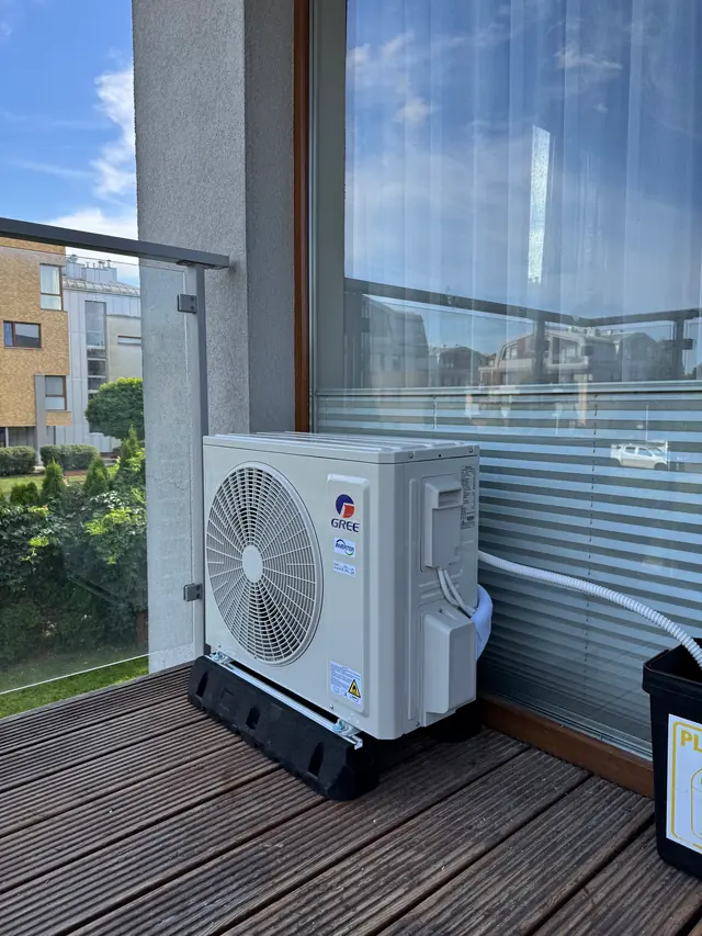 Jednostka zewnętrzna Gree na balkonie z drewnianą podłogą i szklaną balustradą – Kraków